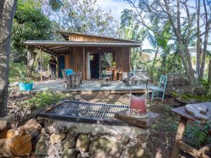 una cabaña en el bosque con una parrilla en el patio en Uka O Te Ra´a Cabaña full equipada. en Hanga Roa