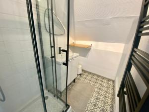 a shower with a glass door and a tile floor at Magnifique duplex pour huit personnes -070 in Rouen