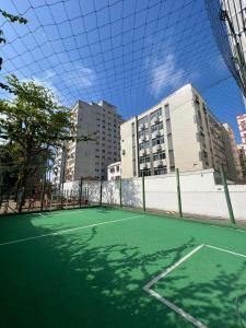 een tennisbaan met gebouwen op de achtergrond bij Lindo Apartamento em Frente a Praia - Santos in Santos