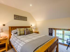 a bedroom with a large bed and a window at The Stables in Llanfair Caereinion
