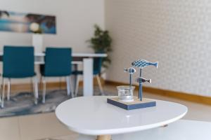 a white table with a small figurine on top of it at Farol Beach Place in Nazaré