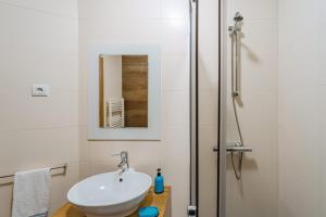 a bathroom with a sink and a shower at Farol Beach Place in Nazaré