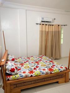 a bedroom with a bed with a flower patterned blanket at Peaceful Stay 1SR in Cotonou