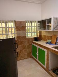 cocina con puertas verdes y encimera en Peaceful Stay 1SR en Cotonú