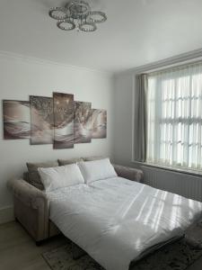um quarto branco com uma cama e uma janela em New look flat In Waterloo em Londres