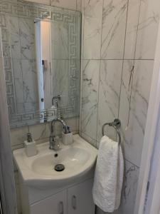 uma casa de banho branca com um lavatório e um espelho em New look flat In Waterloo em Londres