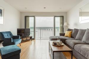 uma sala de estar com um sofá e uma televisão em Lux Waterfront 2 bed Apt, V&A 10min walk, St Andrew's Golf 25min drive em Dundee