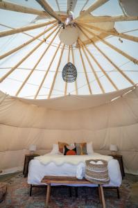 a bed in a yurt with a ceiling at Dreamcatcher Tipi Hotel in Gardiner