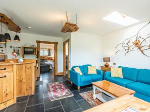 a living room with blue couches and a kitchen at The Lodge in Chester