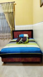 Schlafzimmer mit einem Bett in Blau und Weiß in der Unterkunft Bougenville Homestay in Lembar