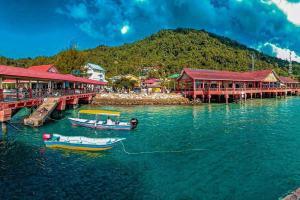 a group of boats in the water near a pier at Perhentian Sri Tanjung , Pulau Perhentian in Perhentian Island