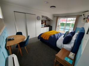 a bedroom with a bed and a desk and a table at DuxHouse BnB in Taihape