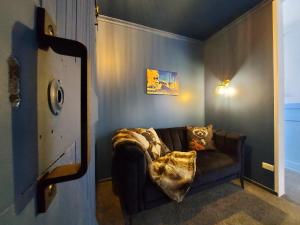 a living room with a couch with a blanket on it at DuxHouse BnB in Taihape