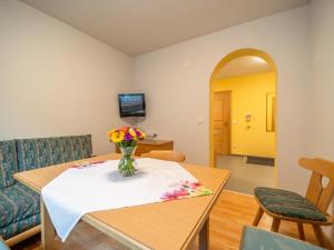 a living room with a table with a vase of flowers at Christoph in See