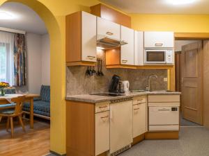 a kitchen with white cabinets and a living room at Christoph in See