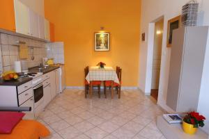 a kitchen with a table and a kitchen with orange walls at Apartments with WiFi Split - 4856 in Split