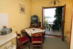 a kitchen and dining room with a table and a television at Apartments by the sea Sobra, Mljet - 4898 in Babino Polje