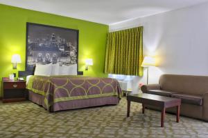 una habitación de hotel con una cama y un sofá en Super 8 by Wyndham De Soto, en De Soto