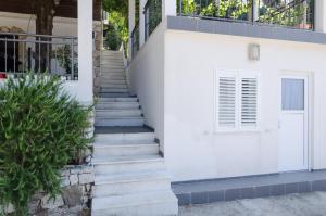 a staircase leading up to a white building with a door at Apartments by the sea Cove Saplunara, Mljet - 4900 in Saplunara