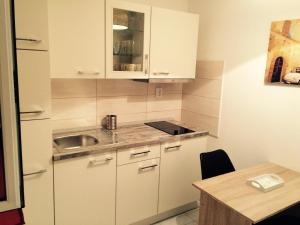 a small kitchen with white cabinets and a sink at Apartments by the sea Cove Saplunara, Mljet - 4900 in Saplunara +17 photos