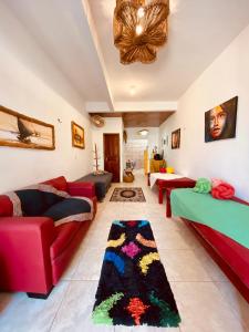 a living room with red couches and a rug at Casa Di Dóres in Trairi