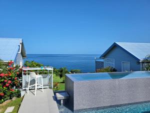 een zwembad met een stoel naast een huis bij Blue Haven Villas Guadeloupe Villa Blue Star in Bouillante