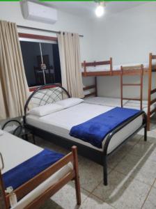 a bedroom with two bunk beds and a window at Ana Terra Barretos Casa de Campo in Barretos