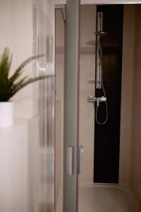 a shower with a glass door in a bathroom at Bon Repos Apartmán in Donovaly