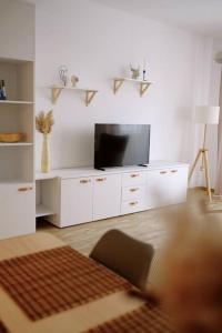 a living room with a television on a white cabinet at Bon Repos Apartmán in Donovaly