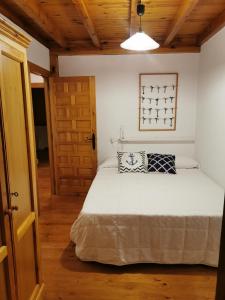 a bedroom with a bed and a wooden ceiling at Casa marinera céntrica en Comillas in Comillas