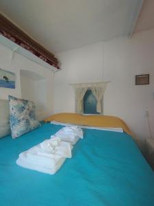 Una cama azul con toallas encima. en Principessa, en Kalymnos
