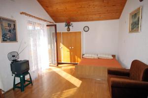 a bedroom with a bed and a tv in a room at Apartments with parking space Supetarska Draga - Donja, Rab - 4991 in Rab