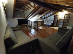 ein Wohnzimmer mit 2 Sofas und einem Flachbild-TV in der Unterkunft Casa marinera céntrica en Comillas in Comillas