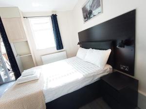 オックスフォードにあるThe Oak Studio -Self contained one bed studio flatの小さなベッドルーム(黒いヘッドボード付きのベッド1台付)