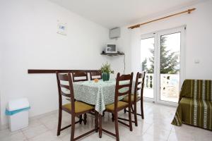 ein Esszimmer mit Tisch und Stühlen in der Unterkunft Apartments with parking spaces Barbat, Rab - 4962 in Rab