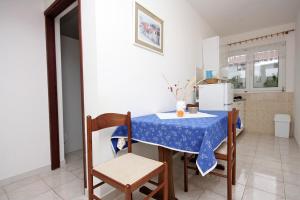 eine Küche mit Tisch und Stühlen und einem Kühlschrank in der Unterkunft Apartments with parking spaces Barbat, Rab - 4962 in Rab + 18 Fotos