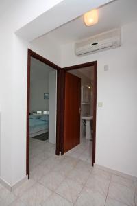 ein leeres Zimmer mit einer Tür und einem Bad in der Unterkunft Apartments with parking spaces Barbat, Rab - 4962 in Rab