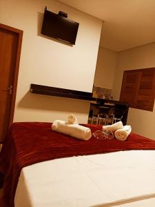 a hotel room with a bed with towels on it at Chalés por do sol in Pirenópolis