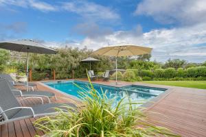 a swimming pool with two umbrellas on a deck at Holiday Haven with Pool in Sorrento