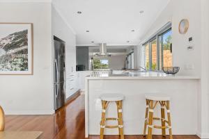 a kitchen with white walls and a counter with stools at Holiday Haven with Pool in Sorrento