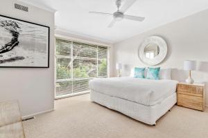 a white bedroom with a large bed and a window at Holiday Haven with Pool in Sorrento +12 photos
