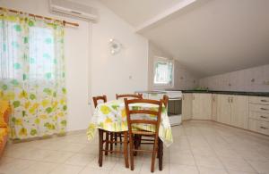 a kitchen with a table and chairs in a room at Apartments by the sea Barbat, Rab - 5005 in Barbat na Rabu