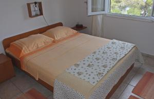 uma cama grande num quarto com uma janela em Apartments by the sea Cove Piskera, Solta - 5175 em Nečujam