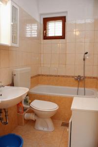a bathroom with a toilet and a sink and a tub at Apartments with a parking space Palit, Rab - 4957 in Mundanije