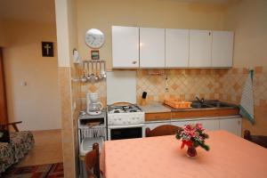 a kitchen with a table with a vase of flowers on it at Apartments with a parking space Palit, Rab - 4957 in Mundanije