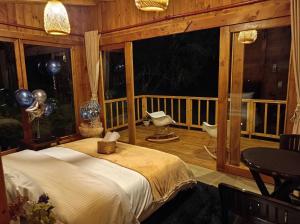 a bedroom with a bed in a room with a balcony at Glamping Paraiso en La montaña in La Calera