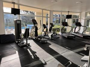 a gym with treadmills and ellipticals in a room with windows at Monoambiente Green Park in Punta del Este