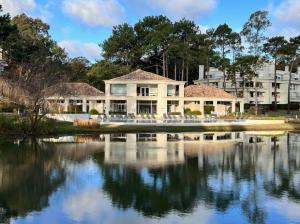 uma grande casa branca com um reflexo na água em Monoambiente Green Park em Punta del Este