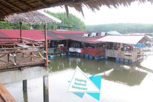 a hazard sign in front of a building on a body of water at Desaru M'Cozy,12pax,Waterpark,BBQ,WIFI in Bandar Penawar