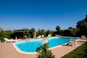 a swimming pool with chairs and a gazebo at Agriturismo De Santis in Castiglioncello
